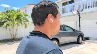 reviewer outside near a car assessing ANC on LG Tone Free T90