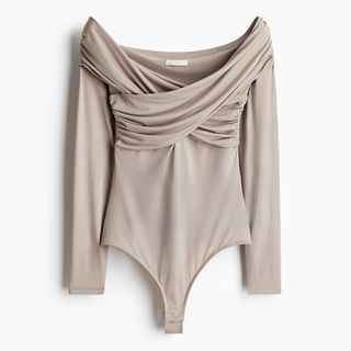 cut out image of a beige jersey bodysuit from H&M with draped detailing across the bust and around the shoulders