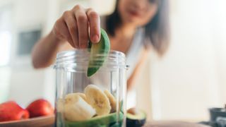 The best foods to eat in a heatwave - woman making smoothies with banana and avocado