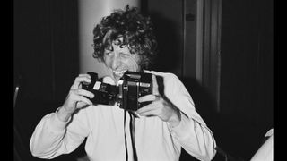 English actor Tom Baker holding a camera, UK, 4th September 1980.
