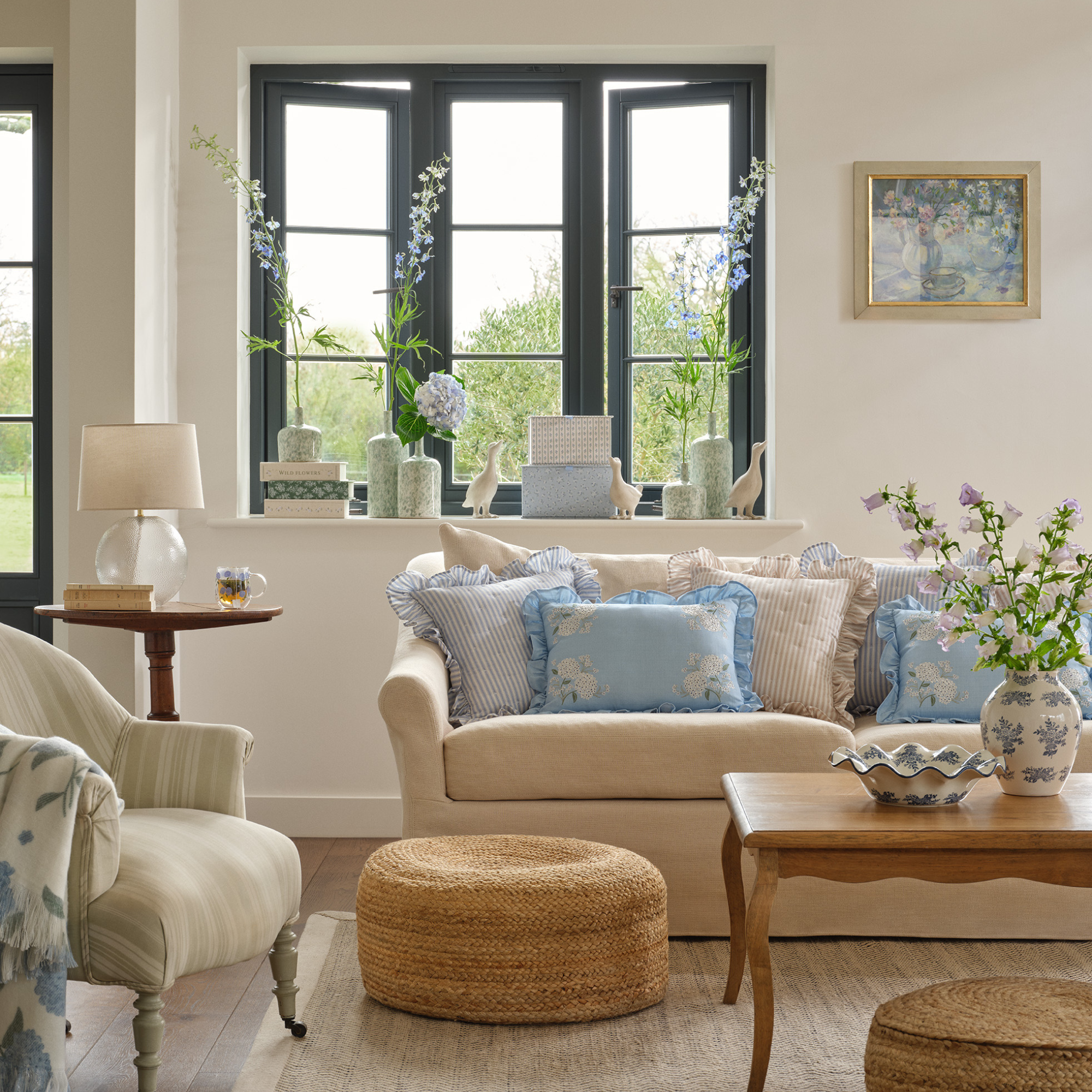 Neutral living room with hydrangea-themed decor, including pillows, vases and ornaments.
