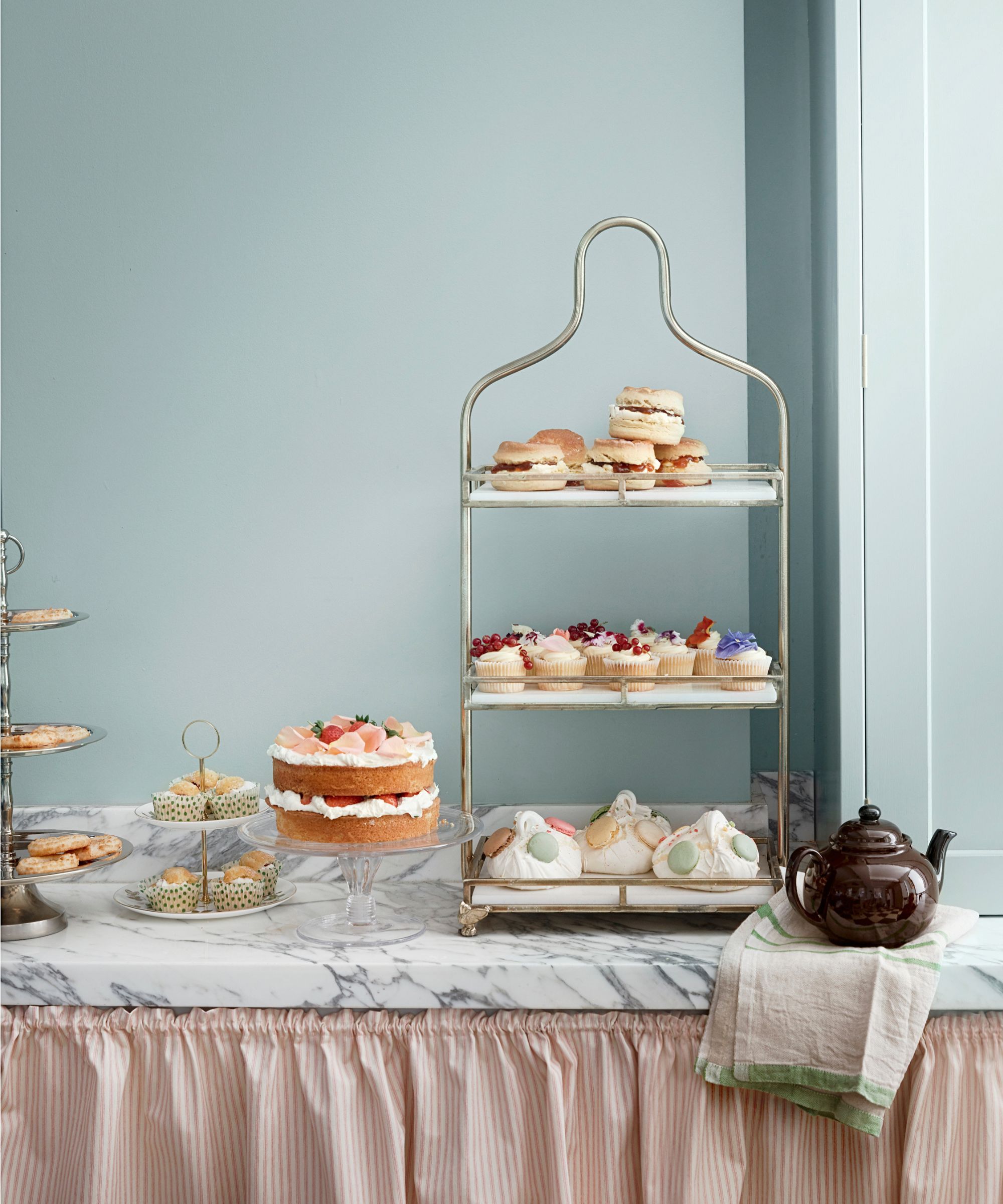 Pale blue dining room with trays of cupcakes and meringues