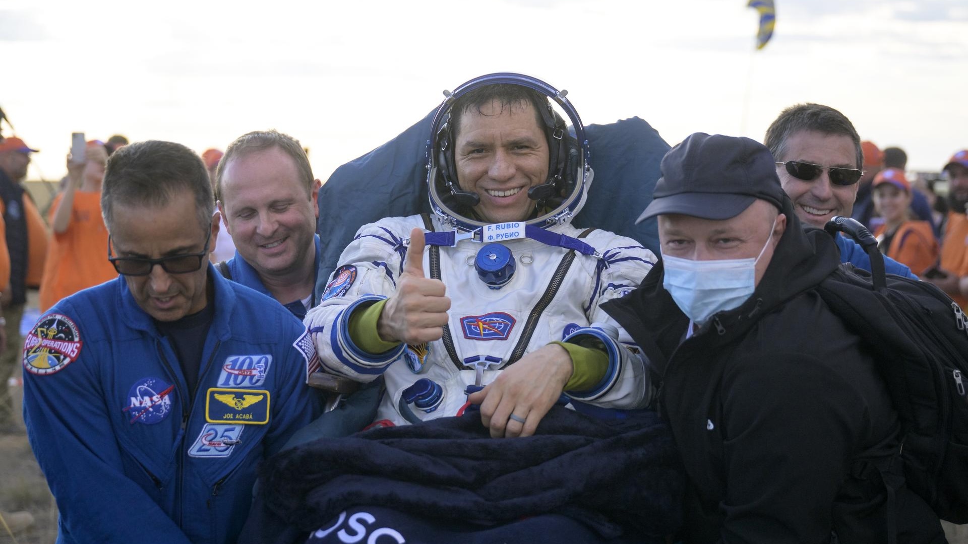 Frank Rubio is worn on a stretcher by a team of men while he gives a boost