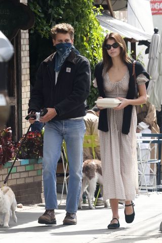 Kaia Gerber walks with Austin Butler in a Doen dress and Mary Jane flats