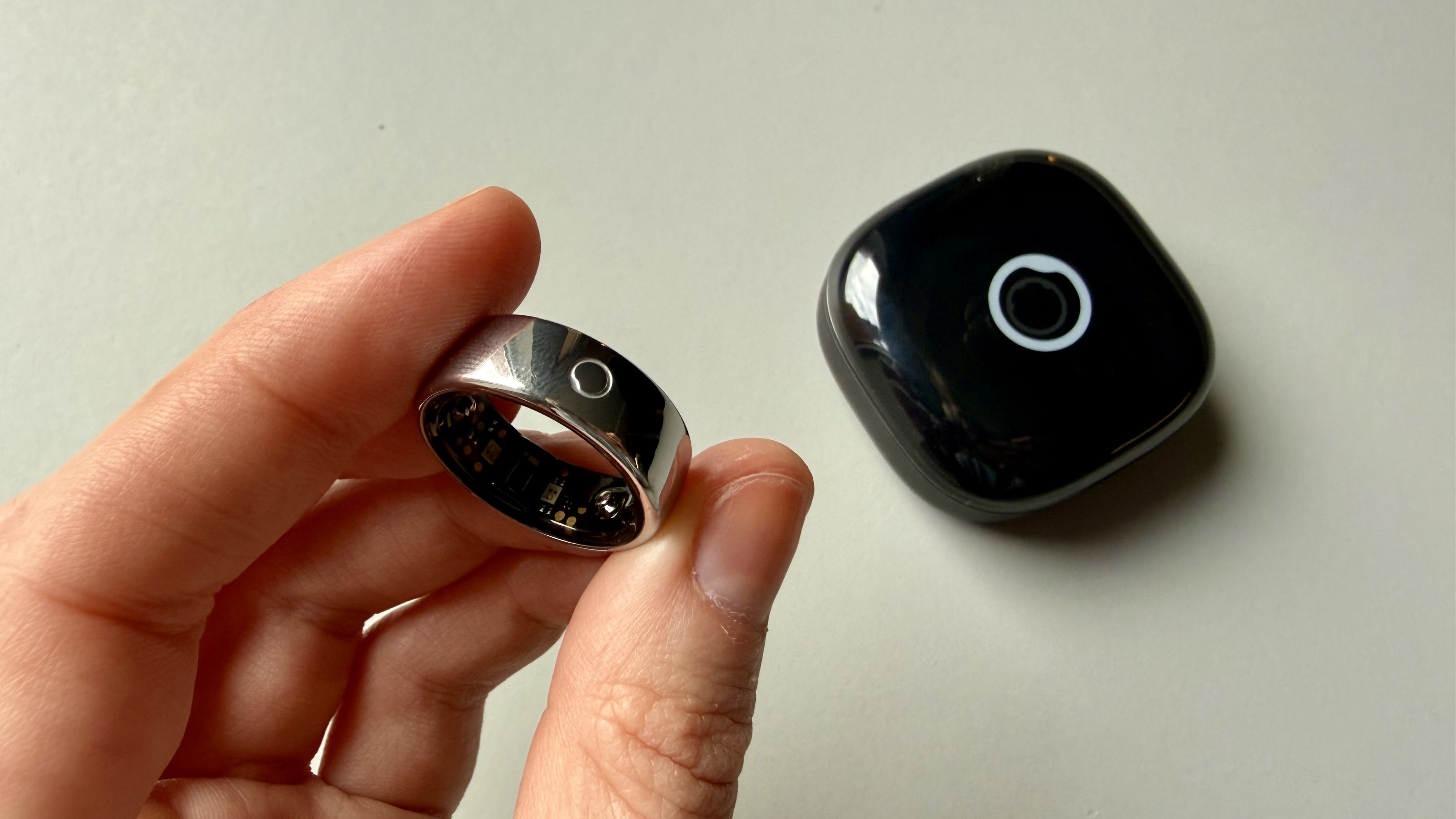 Becca holding the circular ring 2 above its charging case