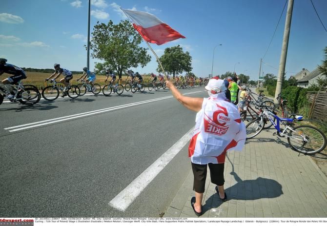 Polish fans wave to the peloton
