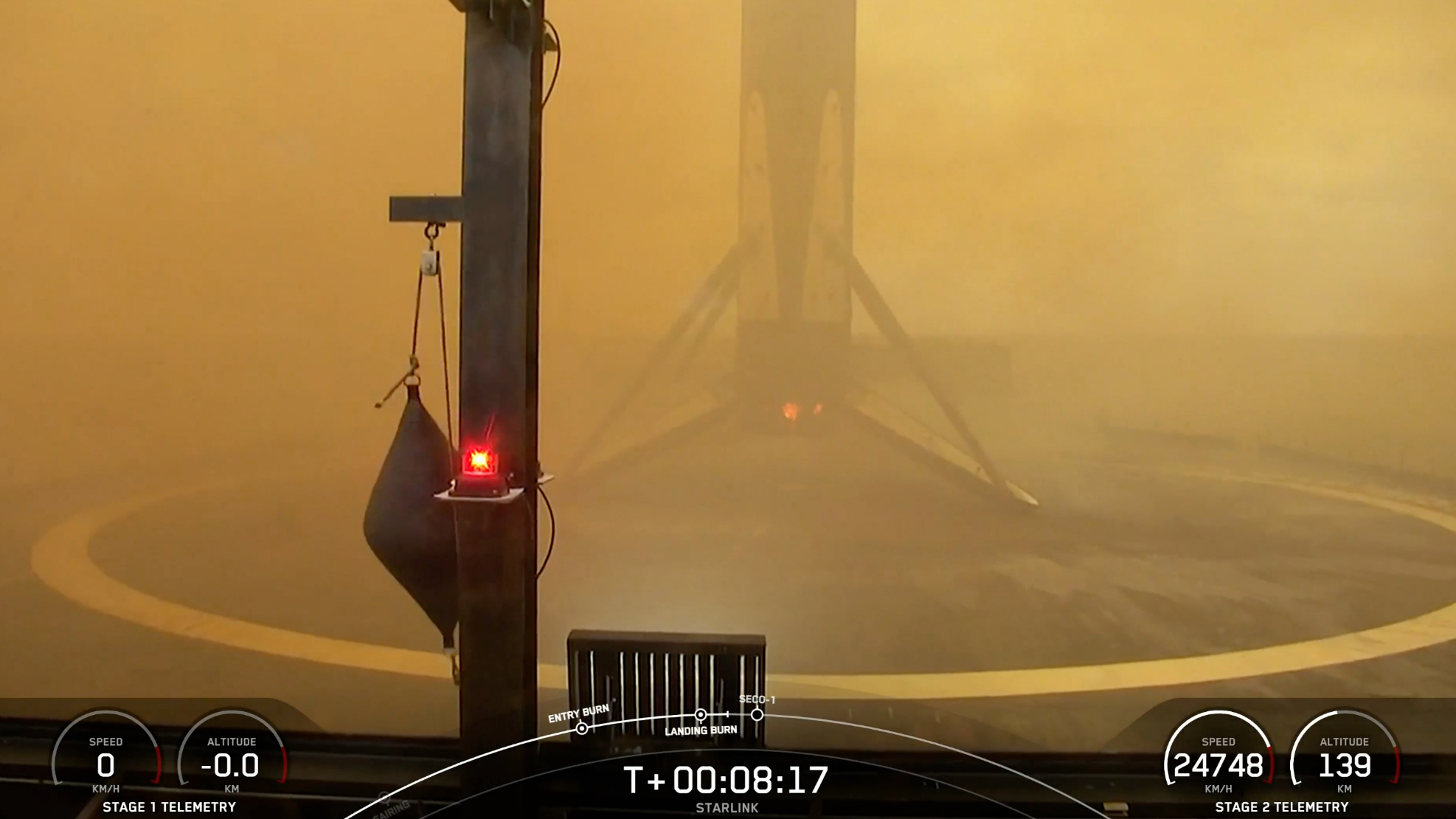 a rocket rests on the deck of a ship at sea, with brownish haze from its engine exhaust partially obscuring the shot