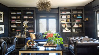 home library with blue walls and bookcases, leather chairs