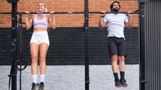 Woman and man performing a pull-up