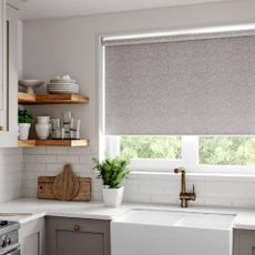 A modern grey kitchen with patterned grey roller blinds from Swift Direct Blinds.