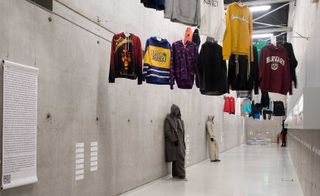 Hoodies hang on a rope with different type of colours,shapes,patterns and sizes.