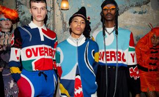 3 male models stood in a studio wearing brightly coloured clothing