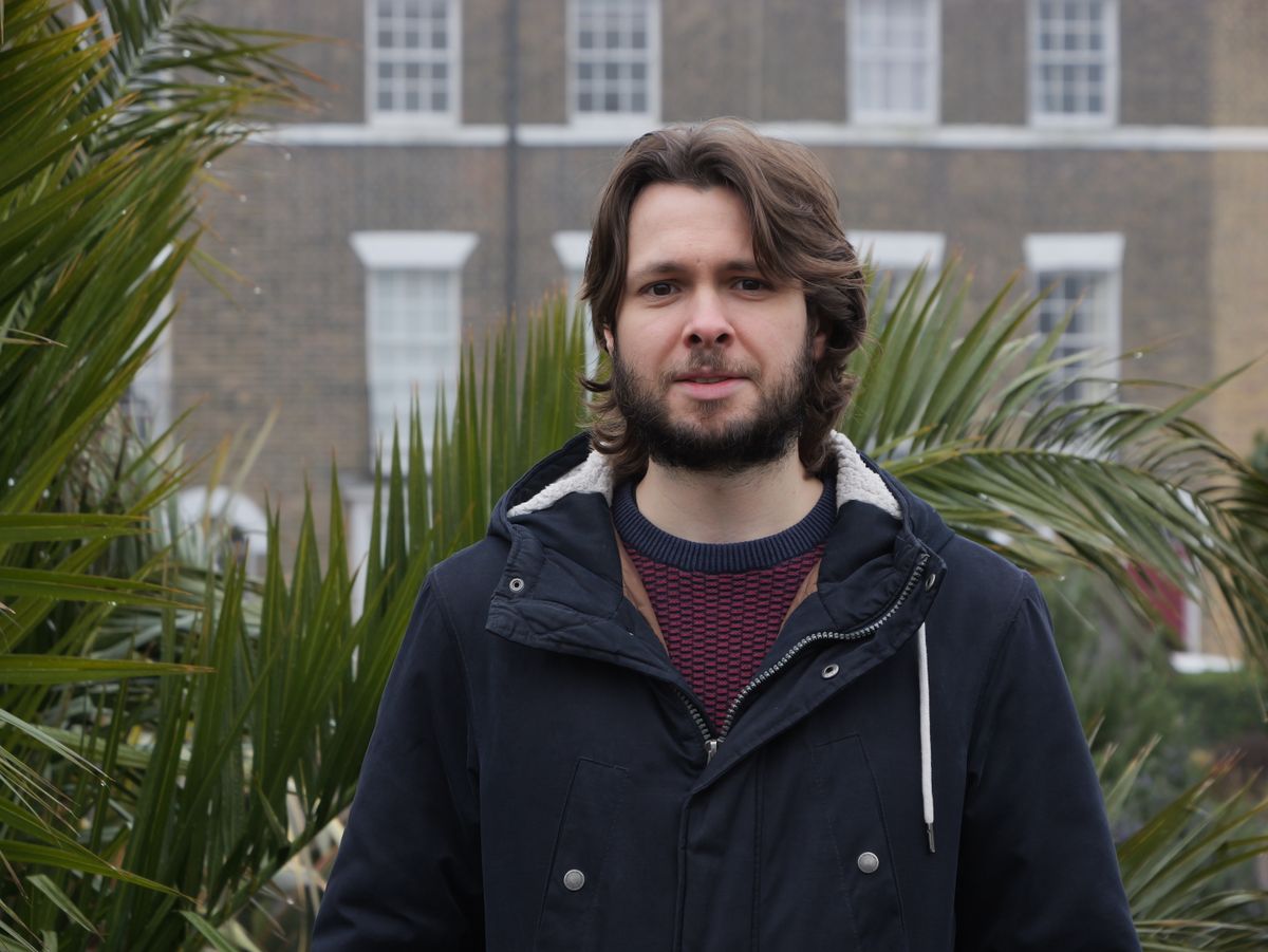 A man standing in front of a date palm