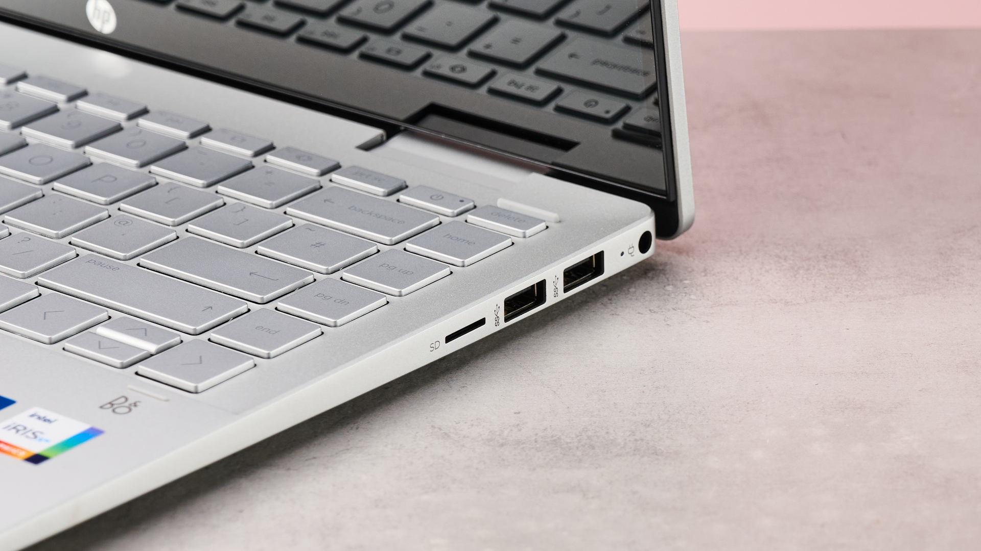 Close-up of right-hand ports on HP Pavilion x360 14, with desk and pink wall in background