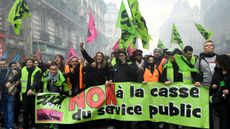 Protestors carry a banner reading 'No to public service cuts' during a demonstration in Paris on Tuesday