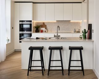 White kitchen interior with bar and black bar stools