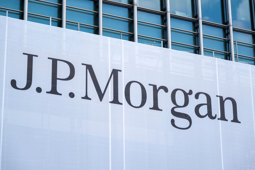 A large banner with the words &quot;J.P. Morgan&quot; handing on windows outside of J.P. Morgan headquarters in London.