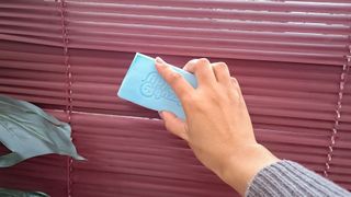 Scrub Daddy Damp Duster on maroon blinds