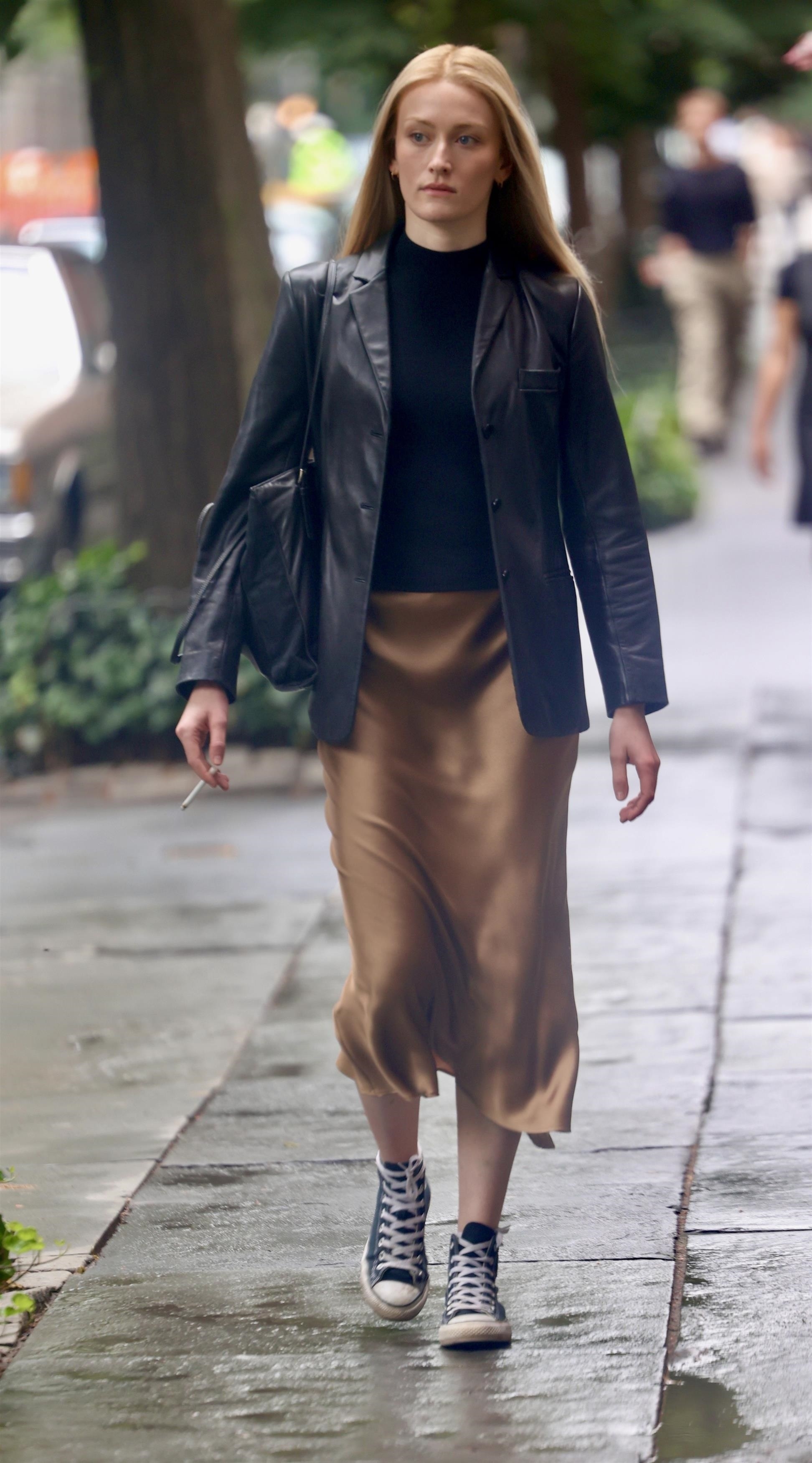 Sarah Pidgeon wearing a leather blazer on the set of Love Story