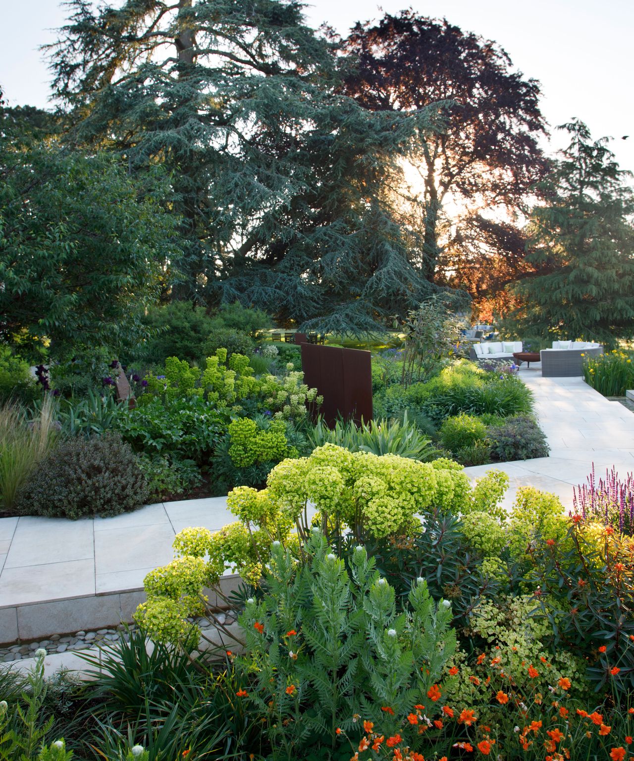 summer garden with garden path running beside a rill