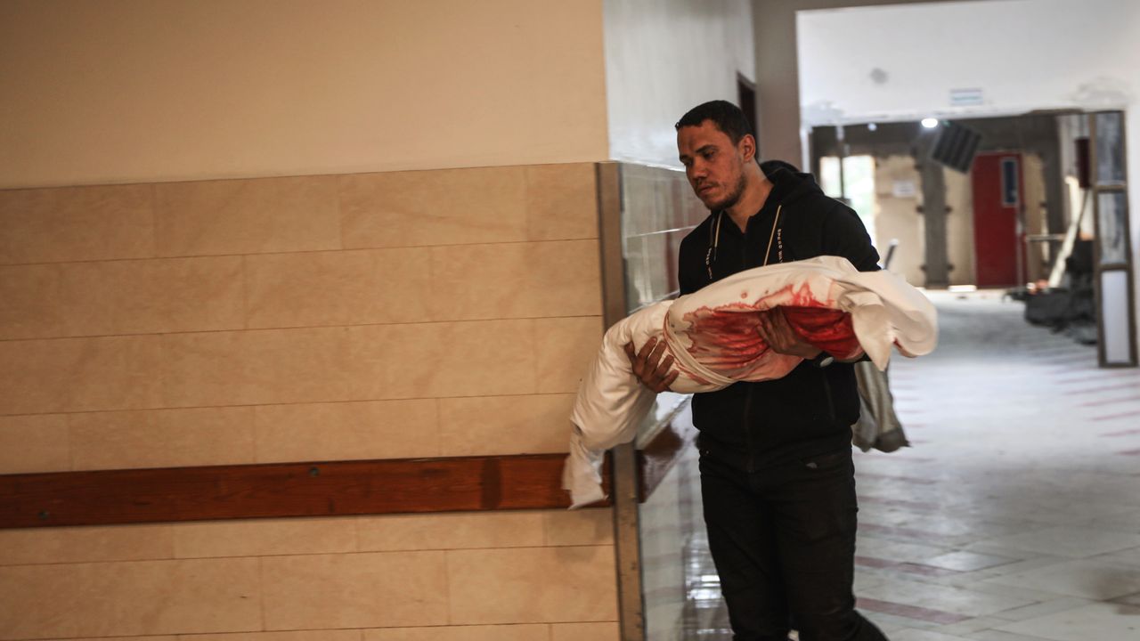 Man carries child killed in March 18 Israeli airstrikes