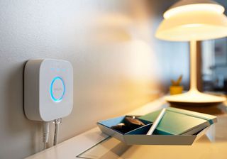 a smart lightbulb hub next to a desk with a bulb turned on