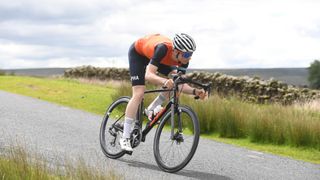 Male cyclist riding in an aerodynamic position on a road bike