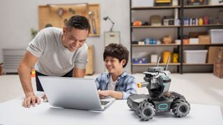 Man and boy use laptop computer with DJI RoboMaster S1