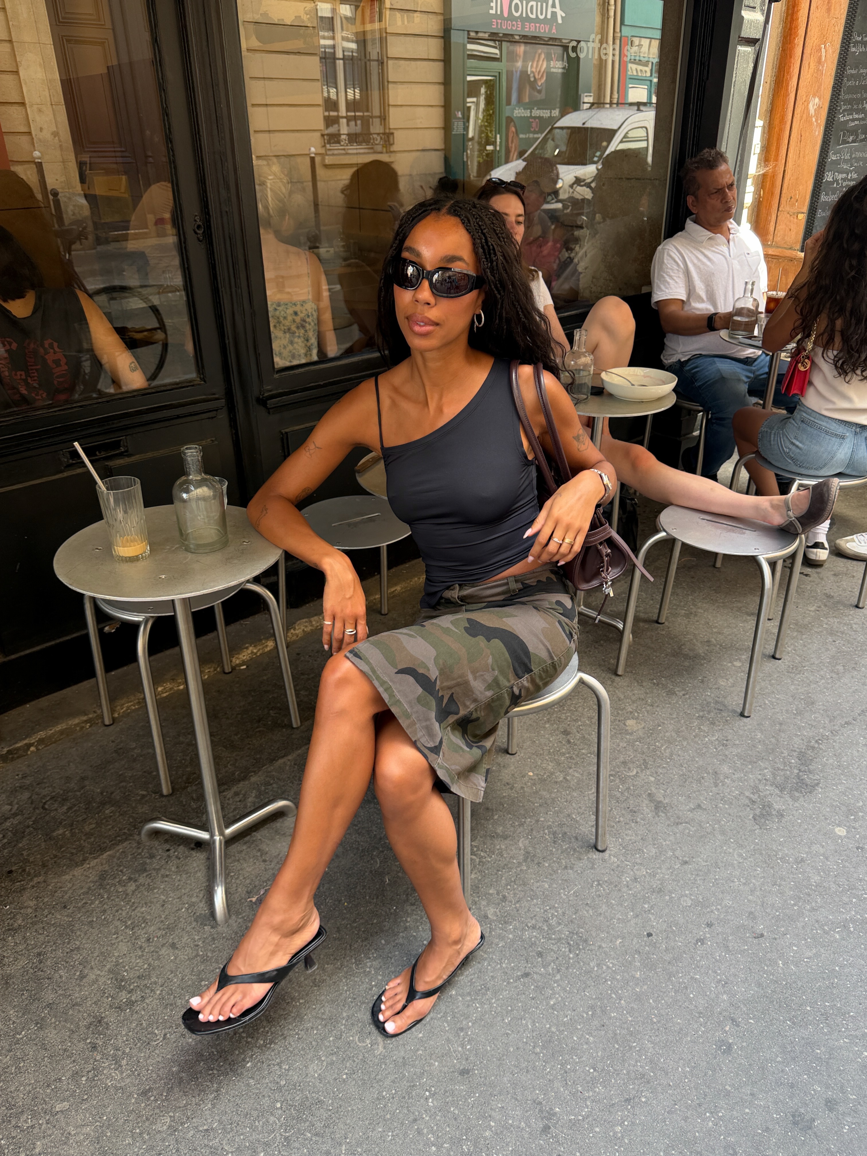An image of @amaka.hamelijnck wearing long cargo shorts with heeled flip-flops and an asymmetrical top.