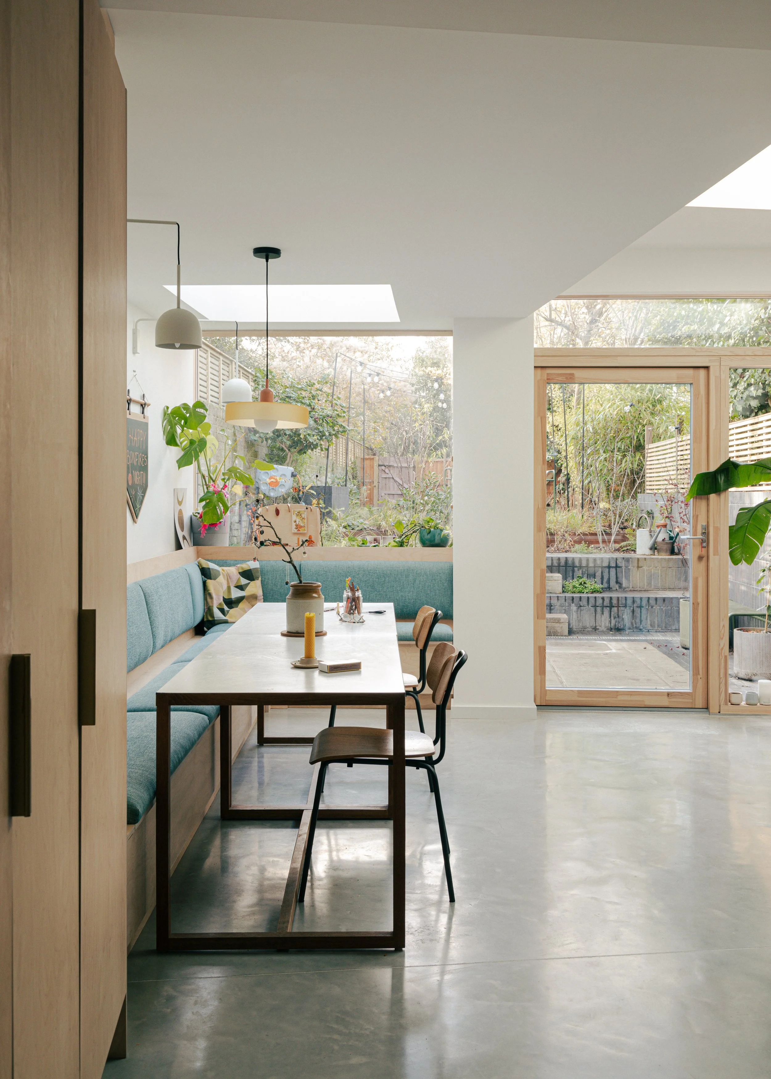 Family dining space in modern kitchen with extra long table and banquette seating