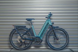 A green Eclipse e-bike leaning against a metal wall