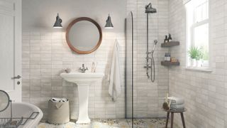 bathroom with white rustic metro tiles, patterned tile floor, pedestal basin. shower screen, wall mounted shower riser, small stool