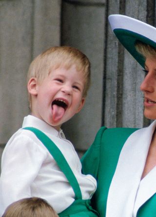 Prince Harry sticking his tongue out as Princess Diana holds him