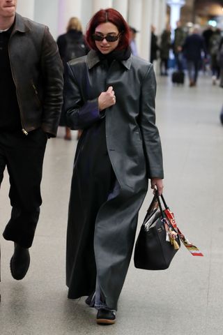 Dua Lipa styles a black Hermes Birkin bag with bag charms.