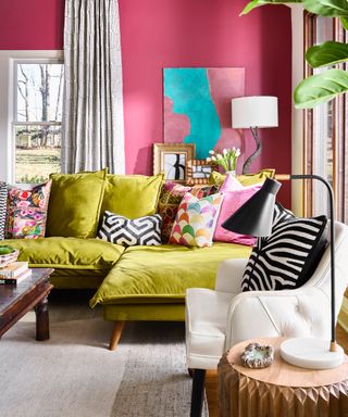 pink living room with lime green modern couch, mixture of couch pillows, gilt frames, black floor lamp, black and white drapes, coffee table,