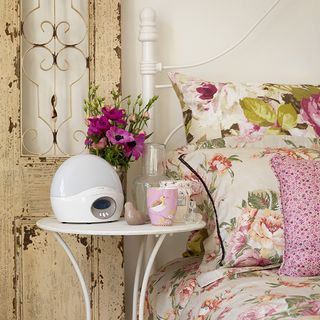 french style bedroom with white bedside table and floral bed linen
