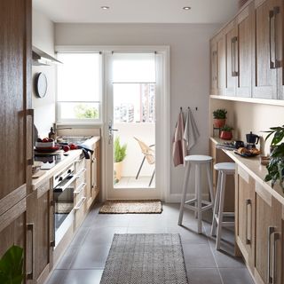 kitchen with white wall wooden cabinets and white door