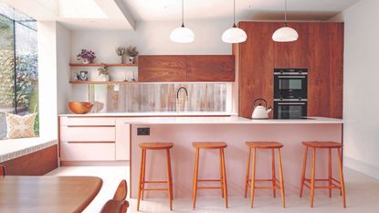 Pink kitchen rennovation with terrazzo wooden stools and bar island