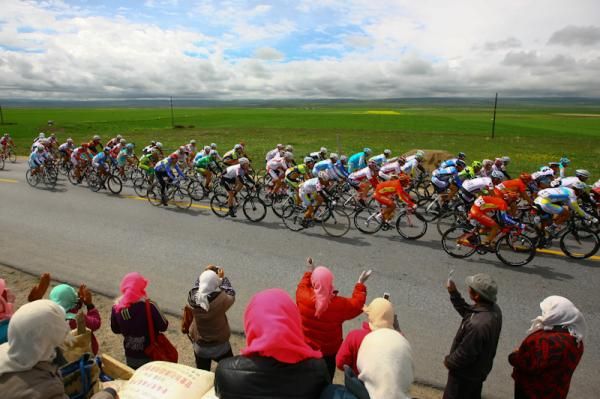 The local Tibetan people wave to the cyclist