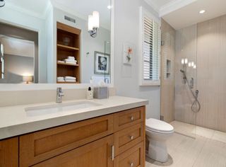 A bathroom with a wooden vanity, laminate floor and walk in shower