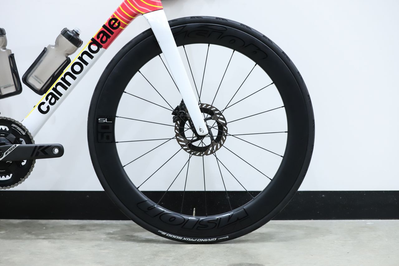 A team-edition Cannondale SuperSix Evo 4 stands against a white wall