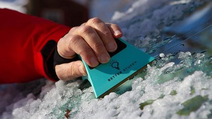 Handheld ice scraper removing ice