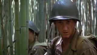 Sean Penn in army fatigues walking through a bamboo forest in The Thin Red Line