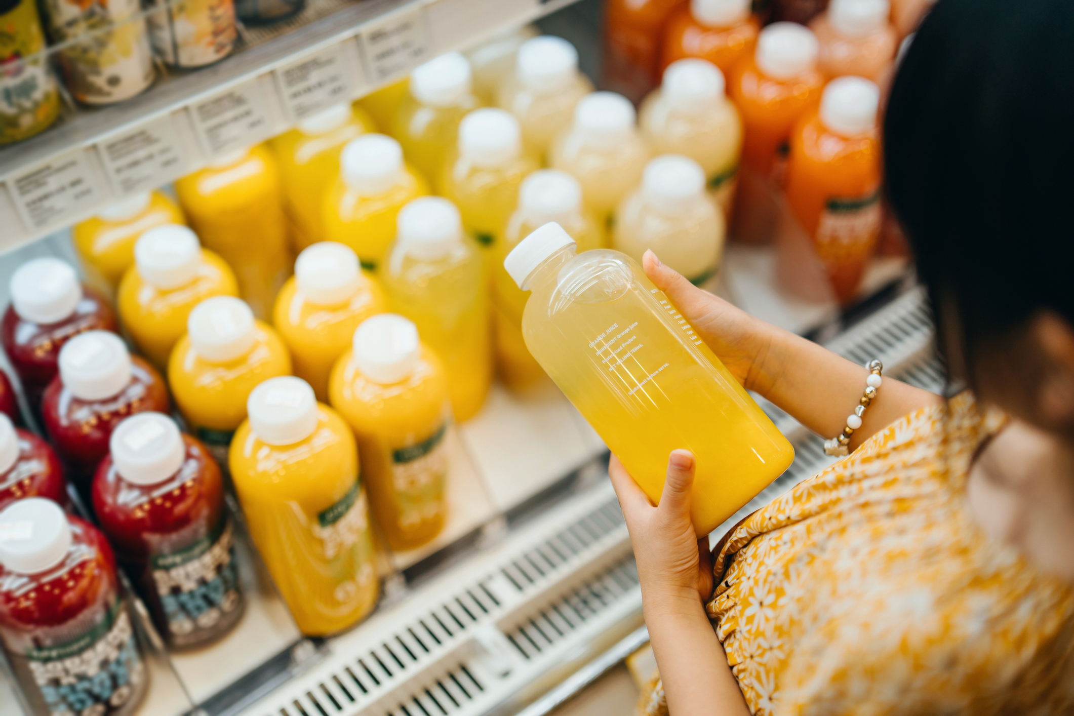 Woman buying orange juice in supermarket