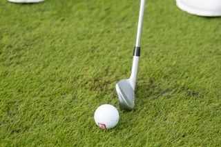 A golf iron striking the turf after the golf ball