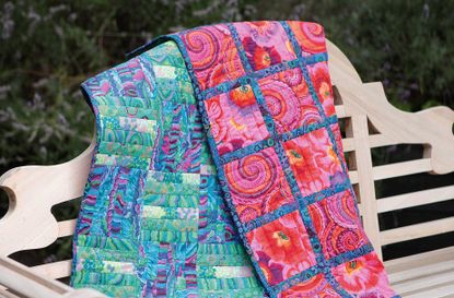 A homemade patchwork quilt on a bench