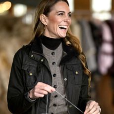 Kate Middleton wearing a grey knit a olive Barbour jacket.