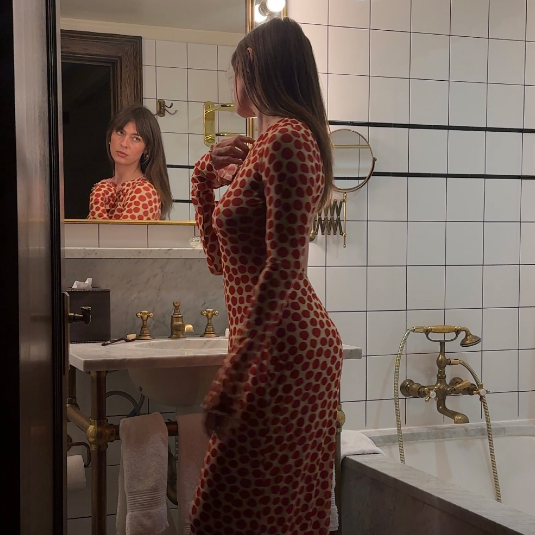 Kathryn Zahorak wearing red polka dot dress in bathroom