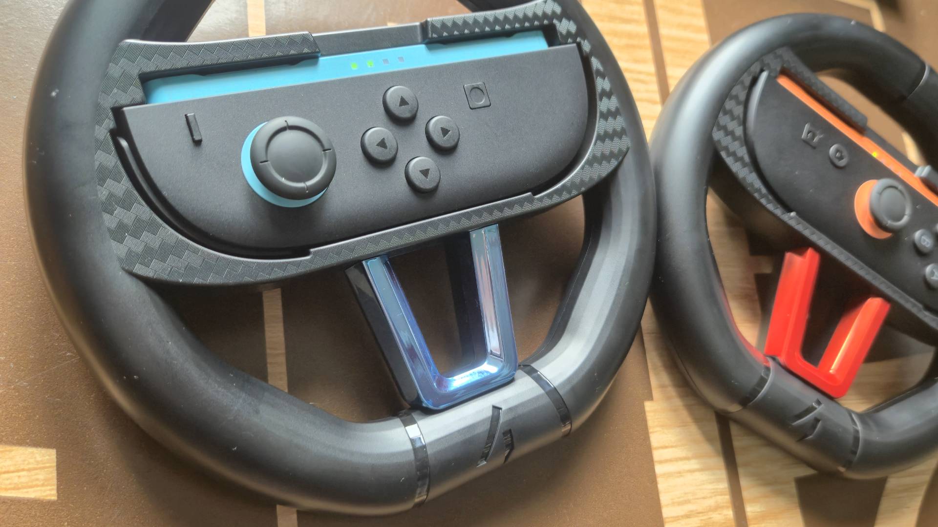 Photo by Rosalie Newcombe of the 4gamer (STEALTH) Switch 2 Twin Racing Wheel controllers sitting on a wooden coffee table.
