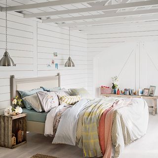 bedroom with white walls and wooden bed with pillows